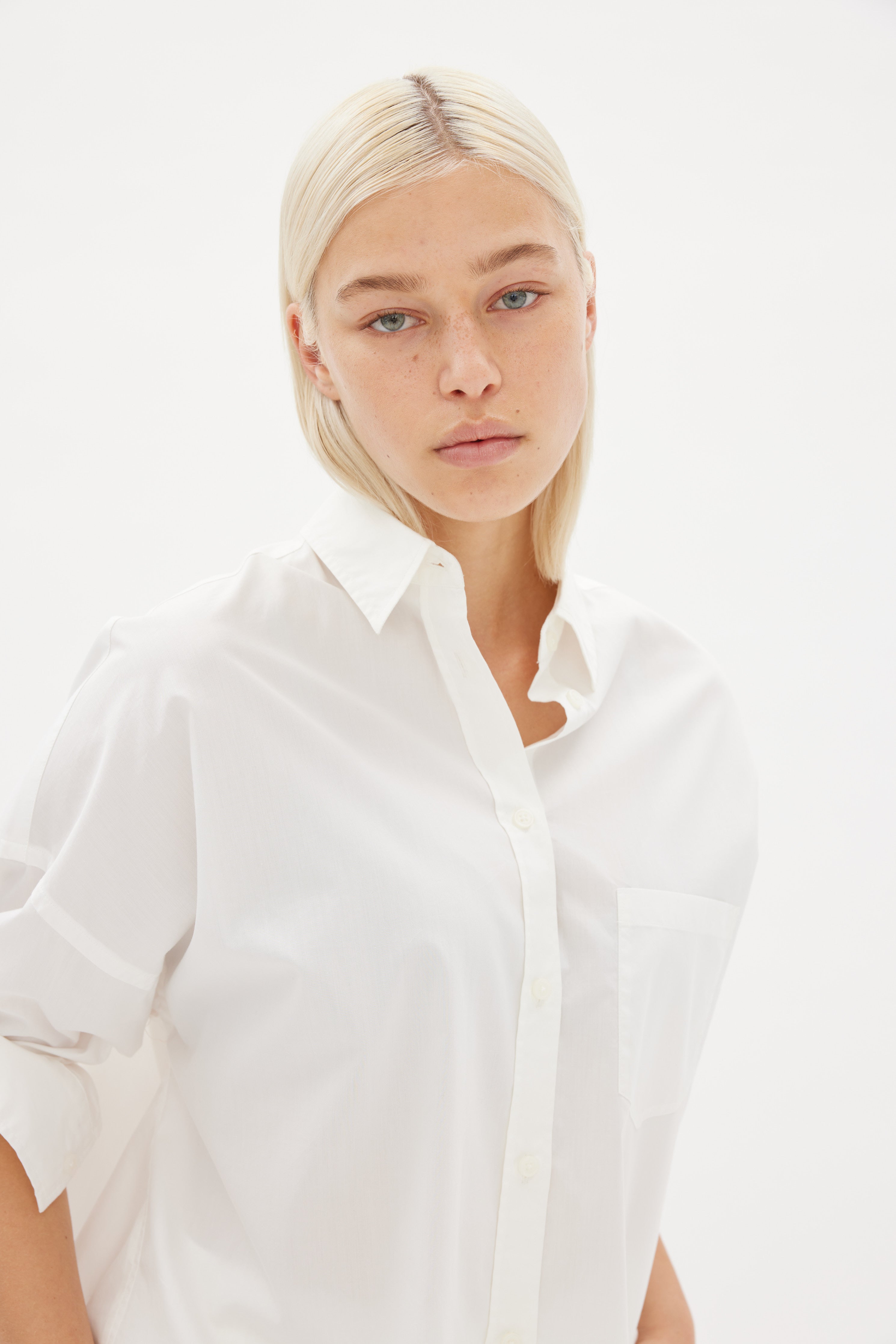 White cotton shirt front view showing relaxed fit and chest pocket detail