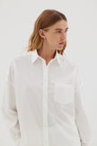 White cotton shirt front view showing relaxed fit and chest pocket detail